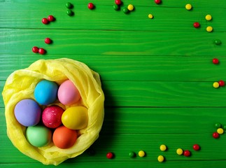 multicolored eggs on wooden green background 