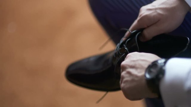 man in a suit tying shoes