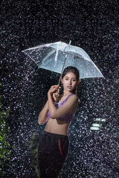 Young woman with umbrella under the autumn shower.