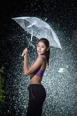 Young woman with umbrella under the autumn shower.