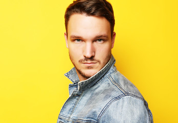 Fototapeta premium Picture of young man standing isolated over yellow background. L