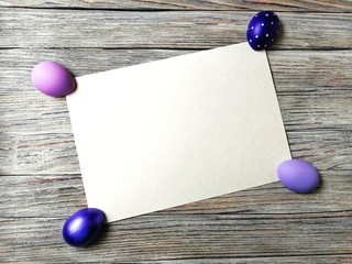 multicolored eggs on wooden white background with scuffs 