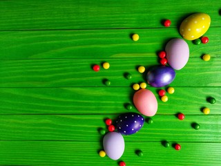 multicolored eggs on wooden green background 
