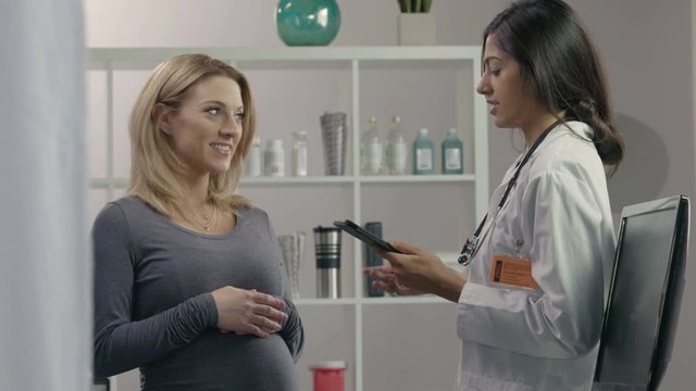 Female health professional consulting with pregnant patient