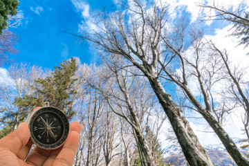 Naklejka premium Compass with natural blur background. Travel concept.