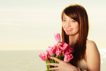Portrait of woman holding flowers on beach
