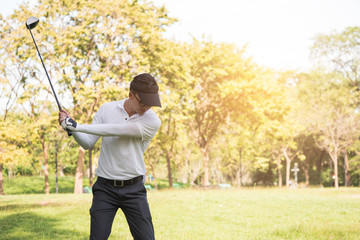 Asian man golf player swinging driver golf club on golf course.