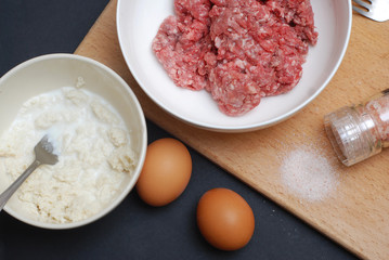 Minced Meat with Eggs and Onion on the Wooden Board over Dark blue Background. Food Preparing. Recipe.