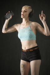 Happy young woman in shorts, dancing with headphones on.