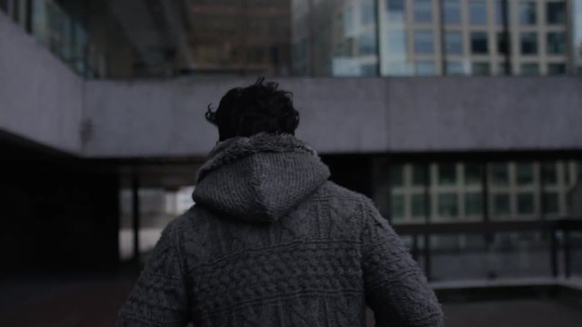 Camera follows a man running through the city, in slow motion