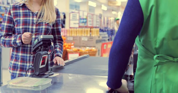 girl pays the products at the checkout with a bank card