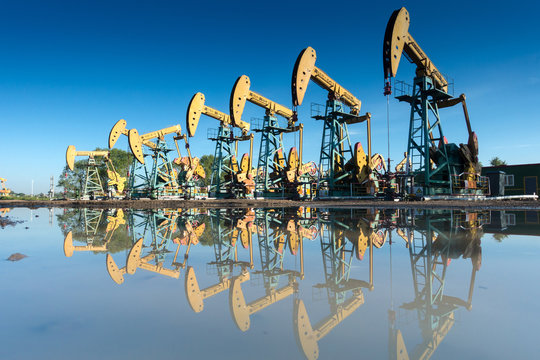 Row of pumpjacks by water