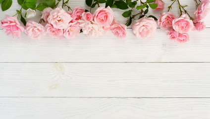 Bouquet of beautiful pink roses on white wooden background.Top view.Copy space