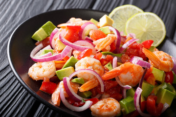 Spicy shrimp ceviche with vegetable salsa close-up on a plate on a table. horizontal