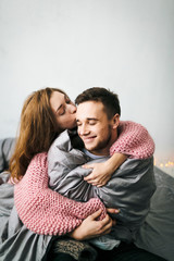 Cute Young Woman Embracing and Kiss Her Boyfriend. A couple having fun in the bed. Artwork. Soft focus