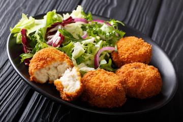 Healthy Eating: Fish cod cake and fresh salad close-up on a plate. horizontal