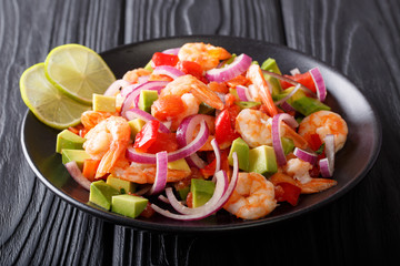 Seviche from marinated shrimp with avocado, pepper, tomatoes and onion close-up on a plate. horizontal