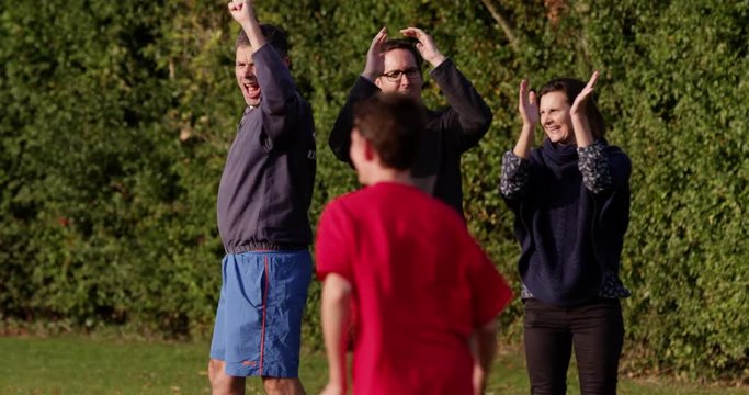 Cheerful parents watching their sons play a soccer game. Shot on RED Epic.