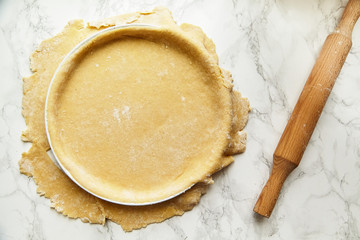 Rolling a pastry for baking a pie and pricking it with fork. Recipe concept
