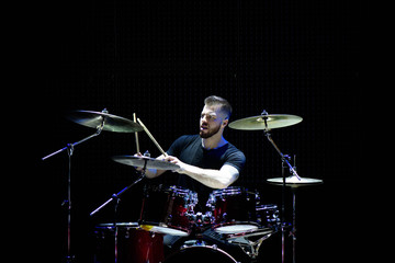 Fototapeta premium Perkusista sylwetka na scenie. Ciemne tło, reflektory dymne