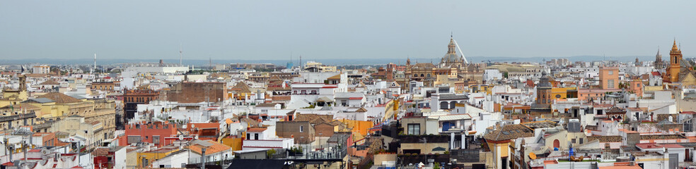 Fototapeta na wymiar A spring May sky over Spanish Seville old town roofs.