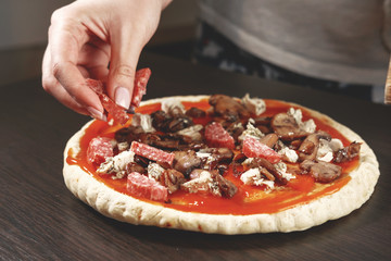 pizza cooking, meat of chiken, sausage salami, thick dough,  pizza crust, chef prepares delicious...