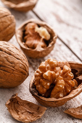  Walnut kernels and whole walnuts on rustic old table