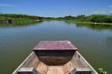 Fototapeta na wymiar Rowing boat boat cruising along a calm blue river