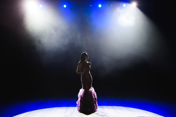 Female singer on the stage holding a microphone