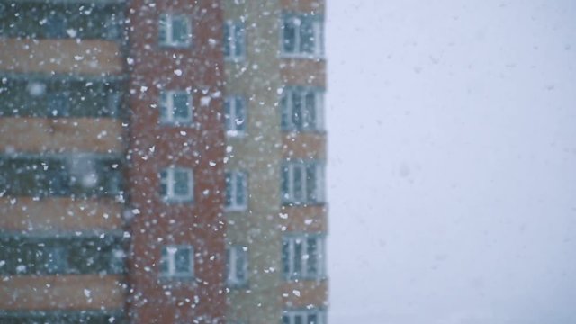 Slow motion of falling snow at the city. Blurred winter background.  Winter cold weather