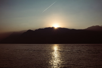 Sonnenuntergang am Berg mit Kondesstreifen wie ein Komet