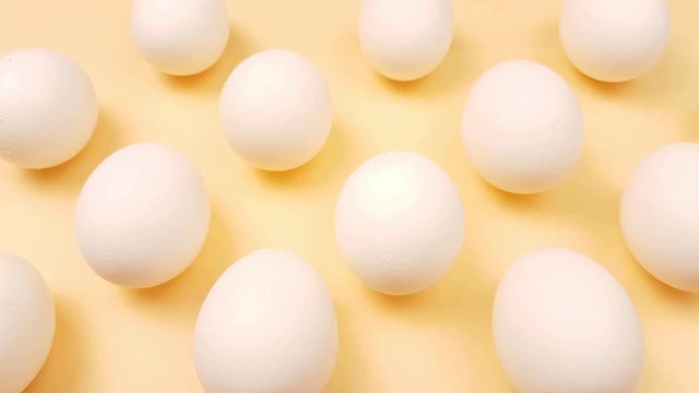 White easter eggs on pastel yellow background close up macro.