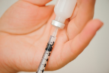 Girl picking up insulin in a syringe close-up. Diabetes.