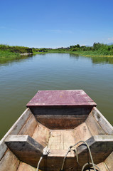 Fototapeta na wymiar Rowing boat boat cruising along a calm blue river