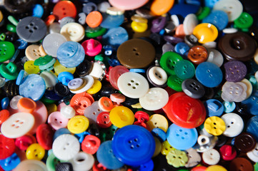 Lot of colorful plastic clothing buttons. Many small round vintage buttons pattern background