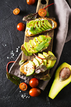 Some toasted with green avocado on black texture