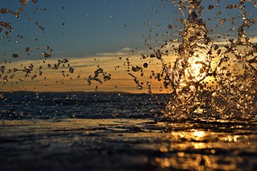 A sun-filled beach scene with a stop-action splashing wave