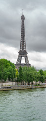 The Eiffel Tower and seine river with dark clouds, narrow