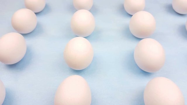 White easter eggs on pastel blue background close up macro.