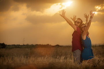 Young couple enjoying together in a wheat field.