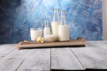 Papier Peint photo Produits laitiers milk products. tasty healthy dairy products on a table on. sour cream in a bowl, cottage cheese bowl, cream in a a bank and milk jar, glass bottle and in a glass