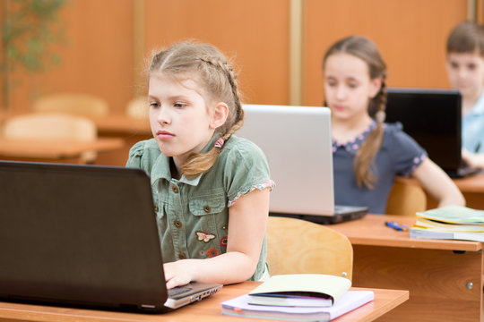 Group Of Elementary School Kids Working Together In Computer Class