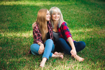 lifestyle and people concept: Two young girl friends sitting together and having fun.