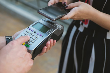 woman use smartphone to make mobile payment with electronic reader. customer paying with near field communication, NFC technology. people use app for online shopping.