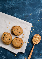 Delicious oatmeal cookies with raisins on concrete blue table background. Sweet pastry.