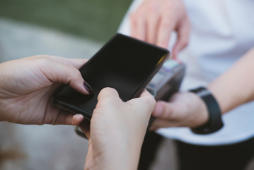 woman use smartphone to make mobile payment with electronic reader. customer paying with near field communication, NFC technology. people use app for online shopping.