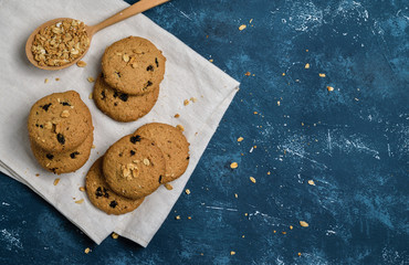 Delicious oatmeal cookies with raisins on concrete blue table background. Sweet pastry.