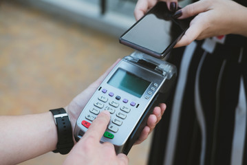 woman use smartphone to make mobile payment with electronic reader. customer paying with near field communication, NFC technology. people use app for online shopping.