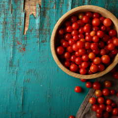 Raw organic tomatoes in wooden bowl