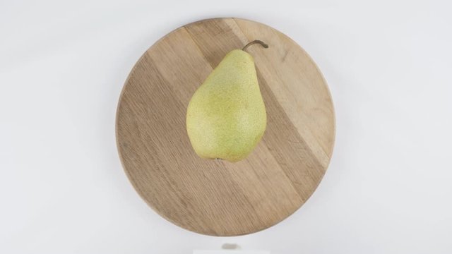 Amount of calories in pear, male hand puts a plate with the number of calories on a pear, top shot 60 fps